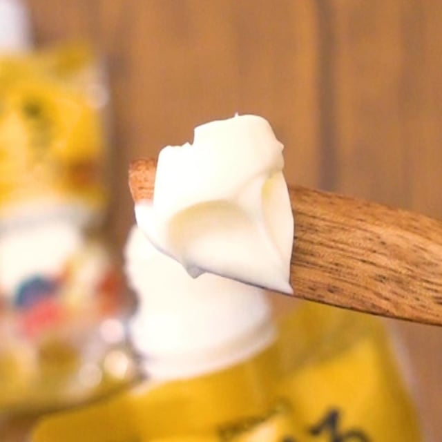 コストコのかけるチーズソースをバターナイフにとっている写真