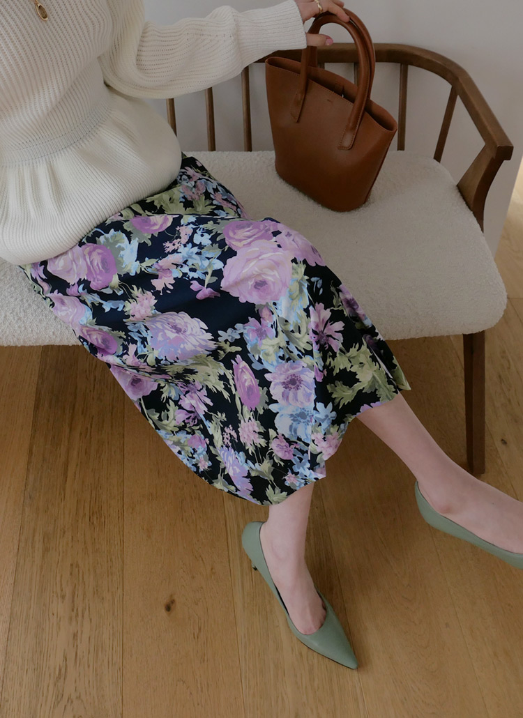 ダークカラーの花柄スカートを履いた女性