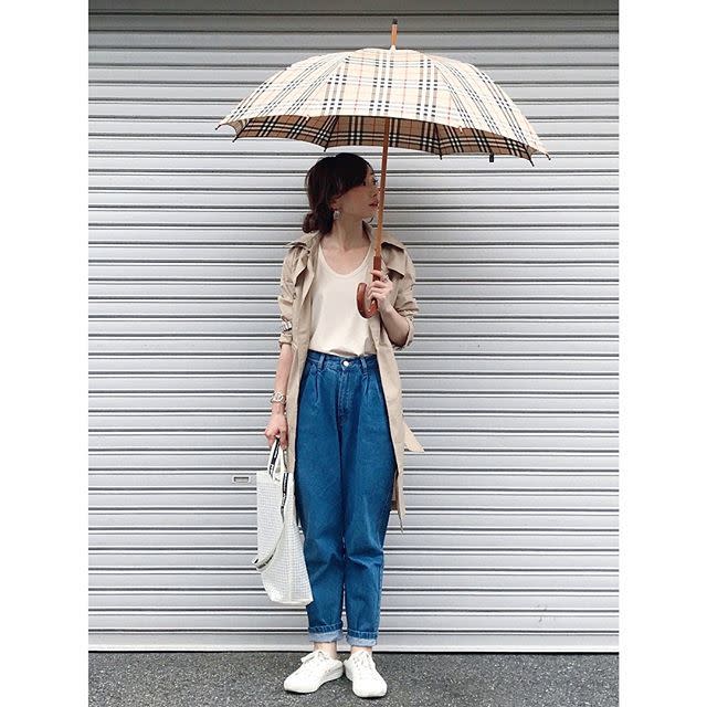 トレンチコートにTシャツデニムにバーバリーの傘の女性