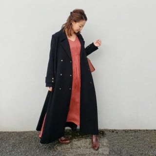 黒ロングコートに赤ワンピースを着た女性