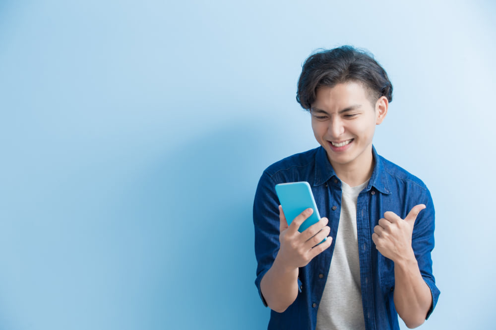 スマートフォンを見て嬉しそうにしている男性