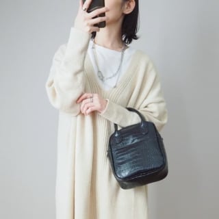 白のニットにシルバーアクセをつけた女性