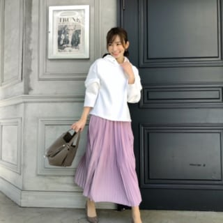 白パーカーにピンクのシフォンプリーツスカートを着た女性