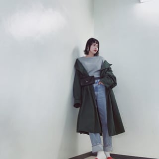 ウエストポーチをアウターの上からつけている女性
