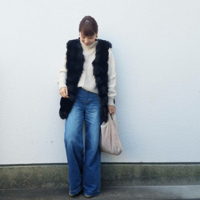 バギーデニムにファーベストを着ている女性の写真