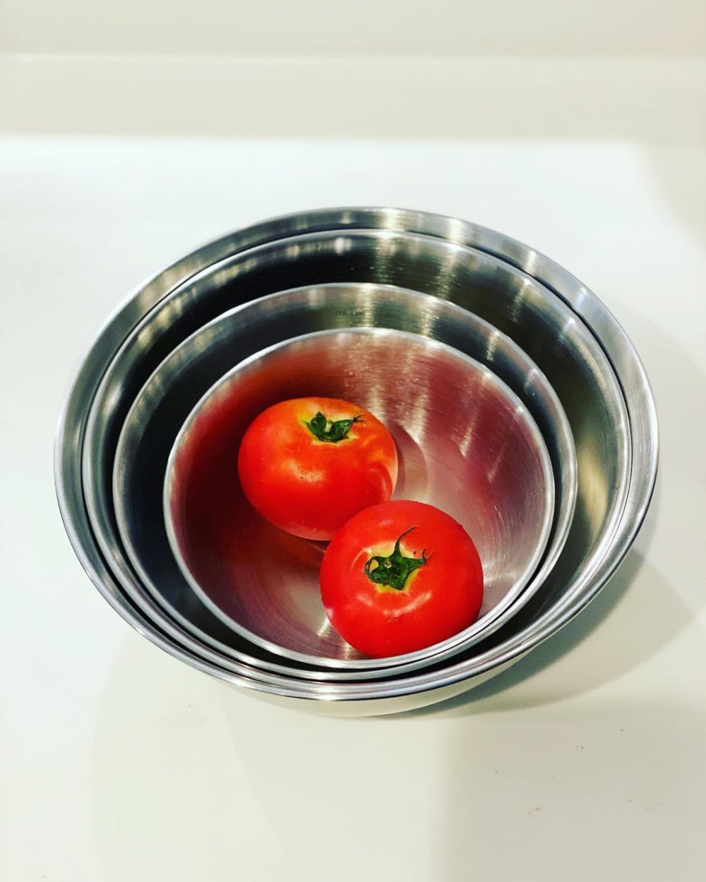 スリーコインズのボウルにトマトを入れている写真