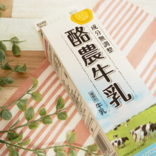 業務スーパー酪農牛乳のパッケージと観葉植物を一緒に撮影した写真