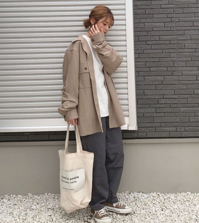オーバーサイズのミリタリーシャツにグレーワイドパンツと白トップスを合わせたコーデ